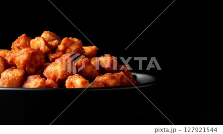 Crispy fried chicken pieces piled high in black bowl, creating mouthwatering and appetizing display Crispy fried chicken pieces piled high in black bowl, creating mouthwatering and appetizing display 127921544