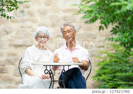 ベンチに座ってお茶を飲むシニア夫婦 ベンチに座ってお茶を飲むシニア夫婦 127921760
