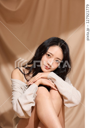 ベージュの布地背景で撮影をした若い女性の高級感のある美容ポートレート 127921779