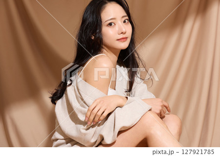 ベージュの布地背景で撮影をした若い女性の高級感のある美容ポートレート 127921785