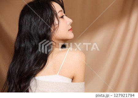 ベージュの布地背景で撮影をした若い女性の高級感のある美容ポートレート 127921794