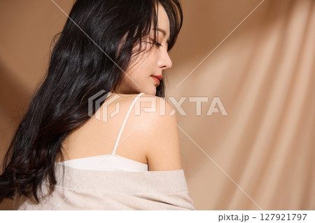 ベージュの布地背景で撮影をした若い女性の高級感のある美容ポートレート 127921797