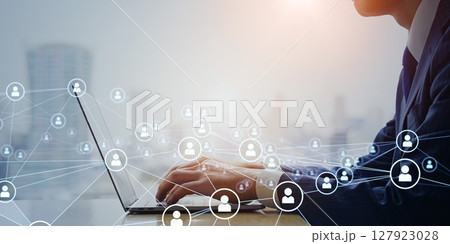 オフィスでノートパソコンを使うビジネスパーソンと人々のネットワークのコンセプト 127923028
