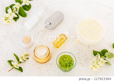 Body care products and branches of jasmine on the white background. Body care products and branches of jasmine on the white background. 127923364