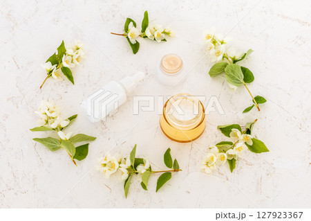 Body care products and branches of jasmine on the white background. Body care products and branches of jasmine on the white background. 127923367