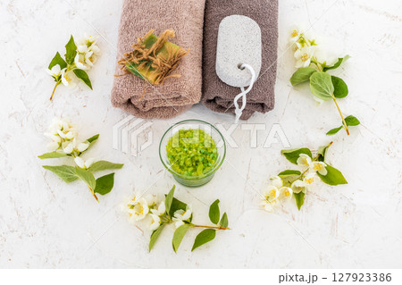 Towels with body care products and branches of jasmine on the white background. 127923386
