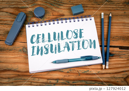 Cellulose insulation. Notepad on a wooden texture background 127924012