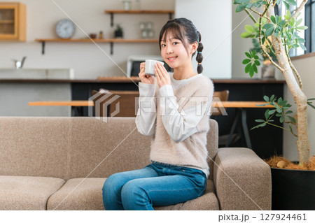 マグカップで朝、家でお茶・白湯を飲むリラックスする小学生,中学生の女の子（温活） 127924461