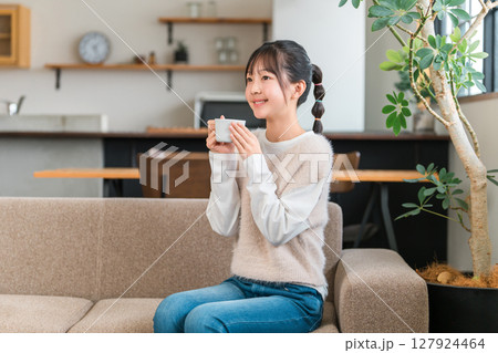 マグカップで朝、家でお茶・白湯を飲むリラックスする小学生,中学生の女の子（温活） 127924464