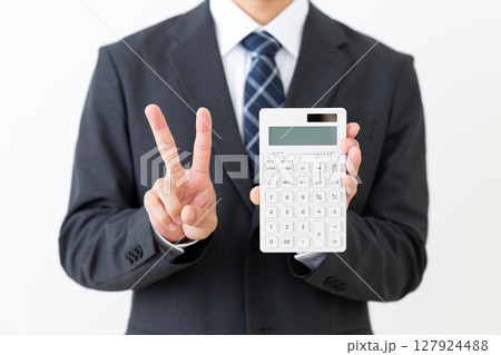 電卓を持って2本指を立てるスーツを着たミドル男性ビジネスマン 電卓を持って2本指を立てるスーツを着たミドル男性ビジネスマン 127924488