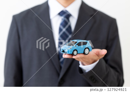 自動車の模型を持つスーツを着たミドル男性ビジネスマン 127924921