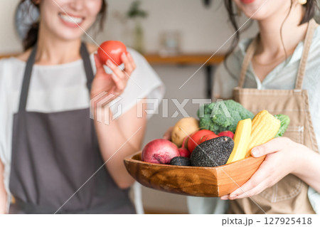 キッチンで野菜を持つ女性・主婦の手元 127925418