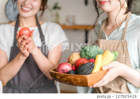 キッチンで野菜を持つ女性・主婦の手元 127925419