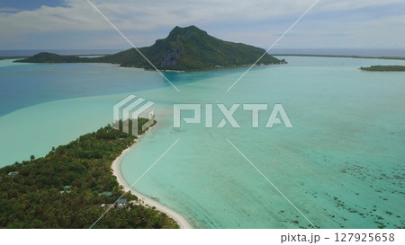 Aerial view of Bora Bora lagoon showing mount Otemanu, lush tropical vegetation, turquoise water, coral reef, and white sand beach in French Polynesia Aerial view of Bora Bora lagoon showing mount Otemanu, lush tropical vegetation, turquoise water, coral reef, and white sand beach in French Polynesia 127925658