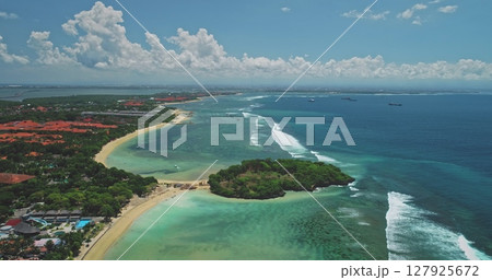 Aerial drone footage showing the beautiful Nusa Dua beach, coastline and tropical ocean in Bali, Indonesia, with waves rolling in and cumulus clouds dotting the sky Aerial drone footage showing the beautiful Nusa Dua beach, coastline and tropical ocean in Bali, Indonesia, with waves rolling in and cumulus clouds dotting the sky 127925672