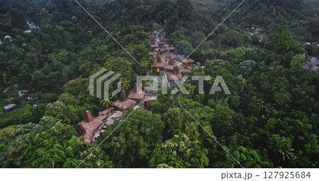 Aerial view capturing a traditional village with typical houses nestled among the lush tropical vegetation of Sumba island, Indonesia, showcasing cultural heritage and natural beauty Aerial view capturing a traditional village with typical houses nestled among the lush tropical vegetation of Sumba island, Indonesia, showcasing cultural heritage and natural beauty 127925684