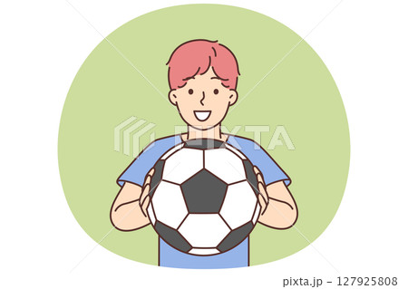 Cheerful boy of school age holding soccer ball and smiling offers to play football Cheerful boy of school age holding soccer ball and smiling offers to play football 127925808