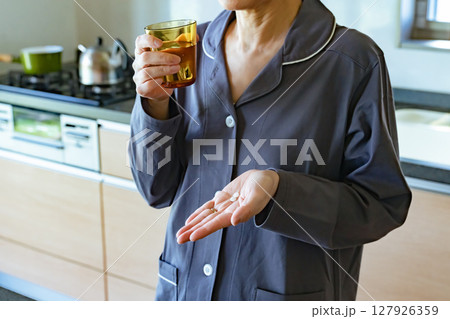 錠剤を飲むシニア女性 127926359