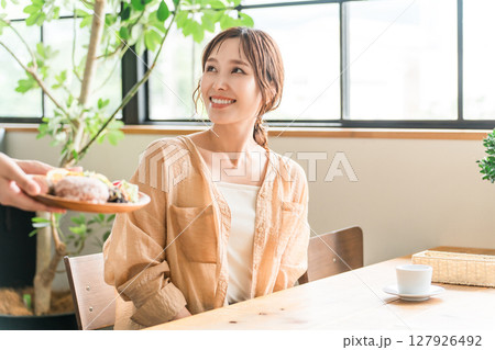 カフェでワンプレートランチを提供する店員と女性客 127926492