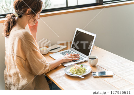 カフェでランチしながらテレワークをする女性の 127926611