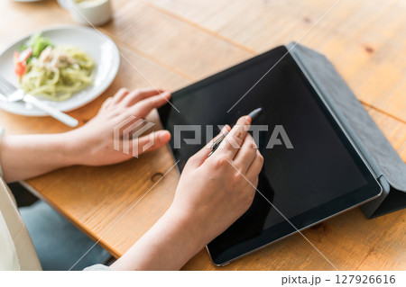 カフェでランチをしながらテレワークをする女性 カフェでランチをしながらテレワークをする女性 127926616