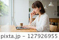 カフェでパソコンを使用し、仕事に集中する女性 127926955