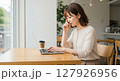 カフェでパソコンを使用し、仕事に集中する女性 127926956