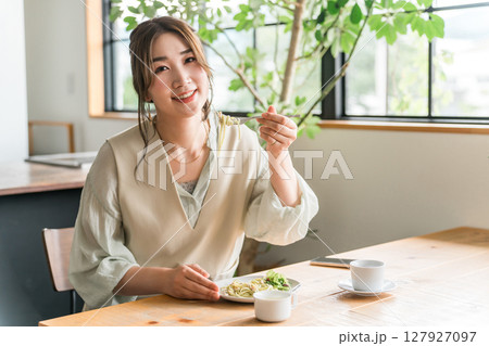 カフェでランチにパスタを食べている若いアジア人女性 127927097