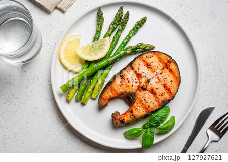Grilled salmon steak with roasted green asparagus 127927621