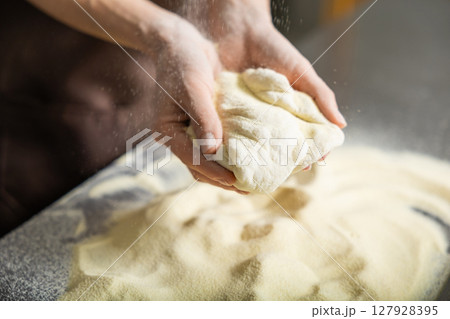 Person rolls dough kitchen flattening carefully preparing pizza meal 127928395