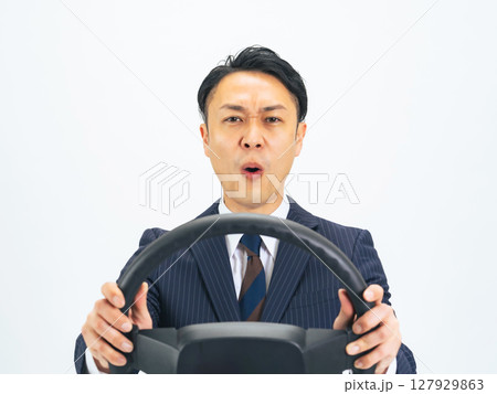 ハンドルを持ってイライラしながら運転するミドルエイジ男性ビジネスパーソン ハンドルを持ってイライラしながら運転するミドルエイジ男性ビジネスパーソン 127929863