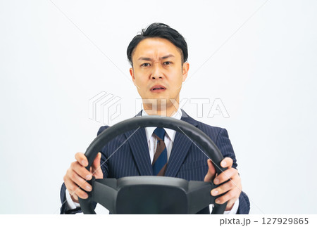 ハンドルを持ってイライラしながら運転するミドルエイジ男性ビジネスパーソン ハンドルを持ってイライラしながら運転するミドルエイジ男性ビジネスパーソン 127929865