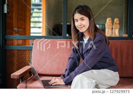 Businesswoman using a laptop in a stylish office environment, showcasing productivity and modern work culture. Businesswoman using a laptop in a stylish office environment, showcasing productivity and modern work culture. 127929973
