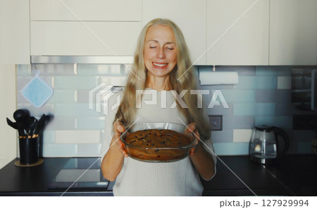 Cooking food, happy smiling mature woman with freshly baked homemade pie in kitchen at home Cooking food, happy smiling mature woman with freshly baked homemade pie in kitchen at home 127929994