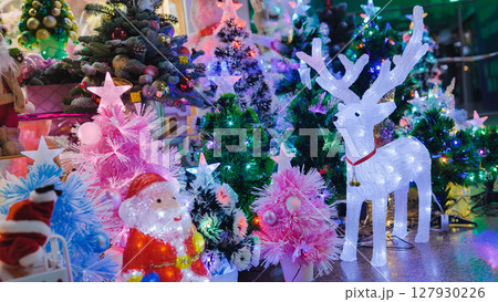 Glowing reindeer and Santa Claus figurine illuminating christmas trees Glowing reindeer and Santa Claus figurine illuminating christmas trees 127930226