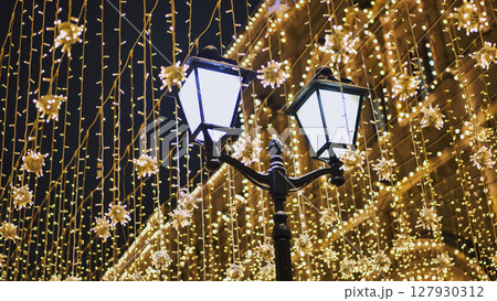 Christmas lights illuminating a street at night Christmas lights illuminating a street at night 127930312