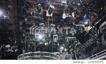 Lighting equipment hanging from ceiling in television studio illuminating set 127930375