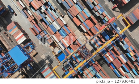 Aerial view of a container terminal with colorful shipping containers and cranes loading and unloading cargo, representing global trade and logistics 127930403