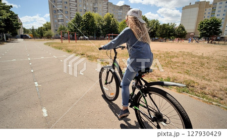 A twelve-year-old girl riding her bike on a warm summer day. A twelve-year-old girl riding her bike on a warm summer day. 127930429