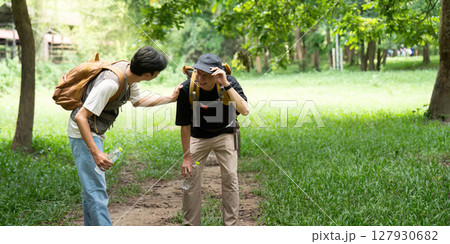 Father Helping Son During Hike. A father provides support to his son on a challenging trail. Father Helping Son During Hike. A father provides support to his son on a challenging trail. 127930682