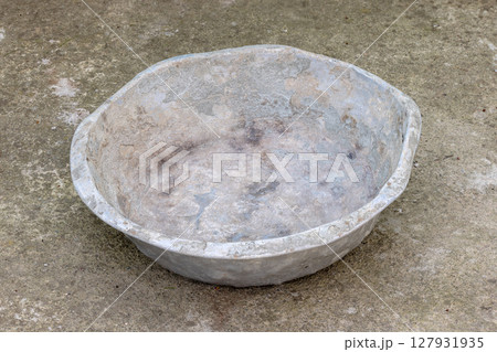 Weathered dented gray aluminum basin on concrete floor Weathered dented gray aluminum basin on concrete floor 127931935