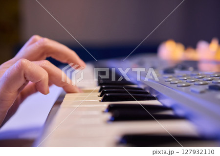 Hands play a keyboard in a modern studio, showcasing creativity and passion for music Hands play a keyboard in a modern studio, showcasing creativity and passion for music 127932110