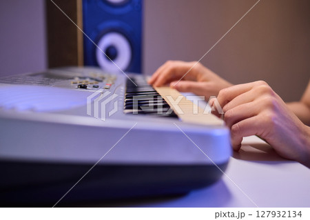 Hands play a keyboard in a modern studio, showcasing creativity and passion for music 127932134