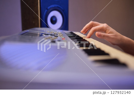 Hands play a keyboard in a modern studio, showcasing creativity and passion for music Hands play a keyboard in a modern studio, showcasing creativity and passion for music 127932140