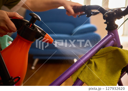 Engaging in Bicycle Cleaning with a Convenient Spray Bottle in a Cozy Environment Space 127932620