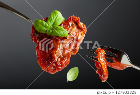 Sun dried tomatoes in olive oil with green basil. Sun dried tomatoes in olive oil with green basil. 127932829