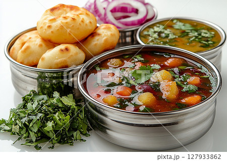Indian Tiffin lunch box. Traditional Indian stainless steel plate with panipuri and tamarind broth nearby. Indian Tiffin lunch box. Traditional Indian stainless steel plate with panipuri and tamarind broth nearby. 127933862