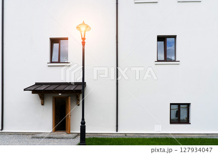 Modern building design house in concrete white with large windows and green lawn Modern building design house in concrete white with large windows and green lawn 127934047