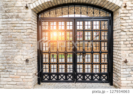Beautiful medieval wooden gate with stone arch in old weathered building Beautiful medieval wooden gate with stone arch in old weathered building 127934063