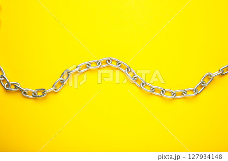 Iron chain of light metal on yellow background. 127934148